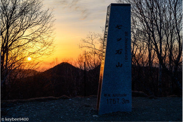 朝日と山頂標識